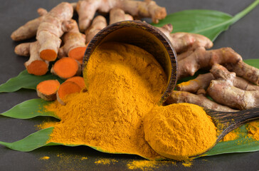 Turmeric (curcumin) powder,leaves and rhizomes on a black background,Used for cooking ,spices.