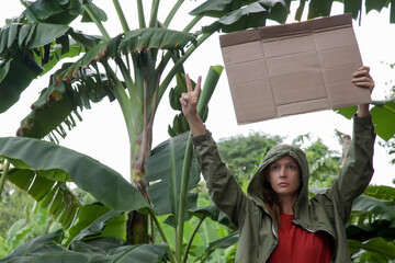 Caucasian woman holding a blank cardboard sign. Peaceful activist protest concept.