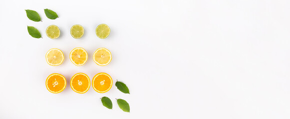 Citrus fruits creative concept with top view of orange, llemon and lime slices arranged on abstract white background with copy space