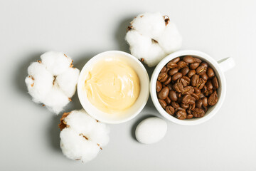  Yellow cream, coffee grains and cotton on a gray background. The concept of natural cosmetics and personal care. Top view, flat lay.