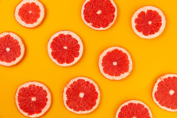 Grapefruit slices seamless pattern on abstract orange background