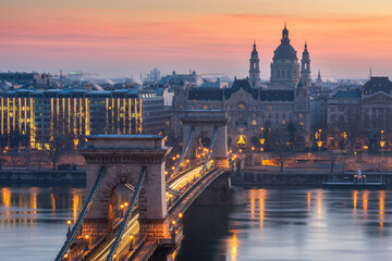 Naklejka premium Close up of St. Stephen's Basilica with Szechenyi Chain Bridge reflect in Danube river, Budapest during twilight