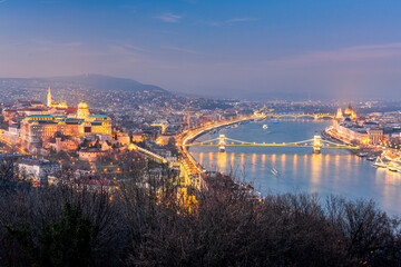 Budapest skyline with Buda castle and Szechenyi Chain Bridge reflect in Danube river during twilight