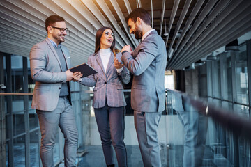 Group of cheerful caucasian elegant dressed real estate agents standing in the building in...