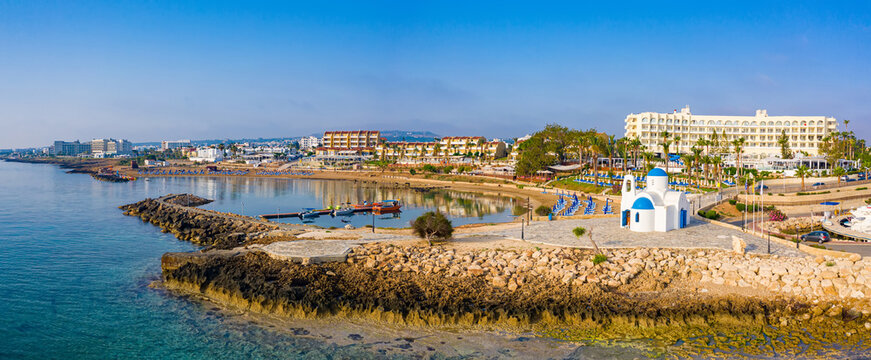 Cyprus. Protaras. White Church view from above. Excursions at Temple Agios Nikolaos. Orthodox temple. Temple with blue domes in Cyprus. Panorama of the Mediterranean coast. Church near the pier.