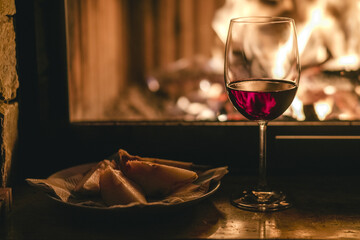 
Glass of wine on fireplace background