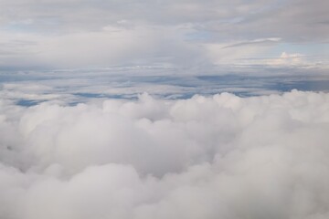 Beautiful white clouds backlit by the sun, view from the airplane window