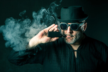 Vaper. Vaping. Man is standing in a cloud of steam. Human with a