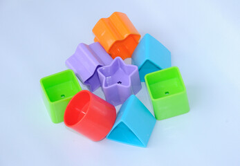 Isolated children's toy blocks in various shapes made of plastic on white background 