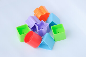 Isolated children's toy blocks in various shapes made of plastic on white background