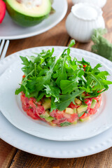 salad with avocado, tomato and red fish with arugula, selective focus