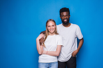 Naklejka premium Young caucasian woman and African man isolated on blue background. Friendship, love different races