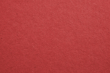 The surface of dark red cardboard. Rough paper texture with cellulose fibers. Saturated color. Background or wallpaper. Top view from above. Macro