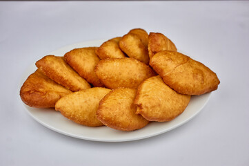golden pies with potatoes on a white background