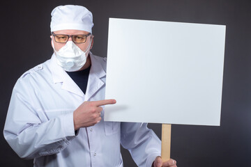 Medic shows a poster. Medic in respirator in protest. Concept - professional union of physicians....