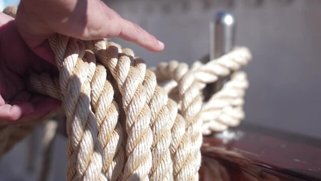 crew member tidying rope in wood ship vessel slow motion
