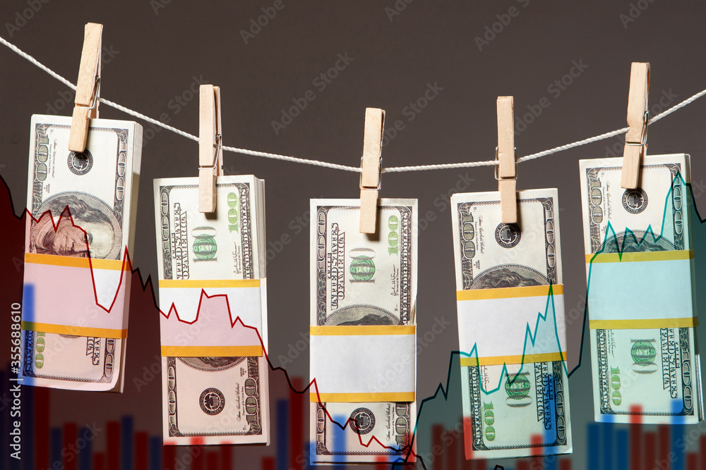 Poster dollars are attached with clothespins to the rope on the background of stock charts and charts. exch