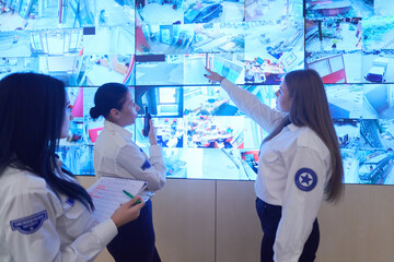 Female security guards working in a security data system control room