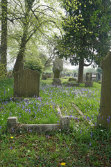 A corner of a quiet churchyard in England with bluebells