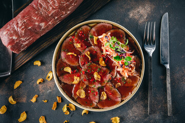 Close up plate of beef Tataki, sliced thinly beef served with a citrus soy dipping sauce