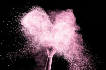 A brush with pink make up powder impact to make a colorful cloud.