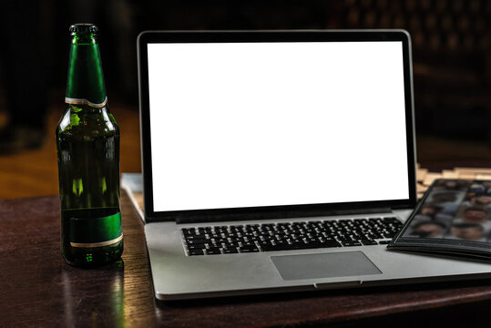 Laptop With Blank White Screen On A Vintage Table With A Bottle Of Lager Beer. Place For Text Mocap