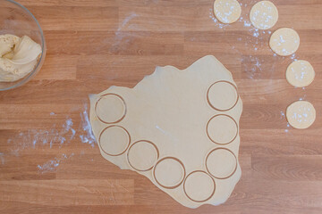 Step-by-step process of cooking dumplings. Top view. All ingredients are mixed. The rolled dough is divided into small circles.
