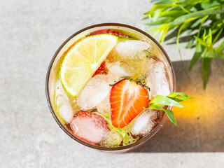 refreshing summer cocktail drink lemonade with ice, lime, strawberries tarragon glass