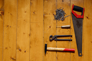 Tools and nails over wooden surface
