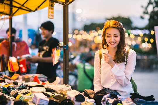 Happy traveler asian woman in shopping street night market at dusk in Thailand