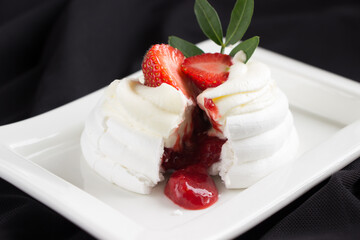 Pavlova cakes  decorated fresh strawberries cracked with strawberry confiture