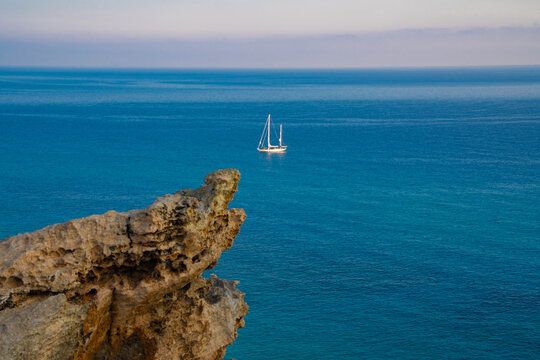 View at the sea from rocks on a sailing boat