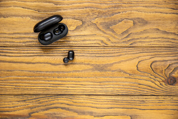 wireless earbuds on wood background