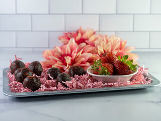 Chocolate covered Strawberry cake balls arranged on a rustic met