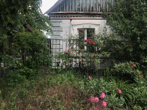 old light house with a fence of planks and flowers