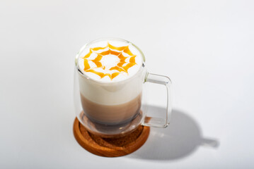 Coffee with Milk froth and caramel in double layer grass on woodplate