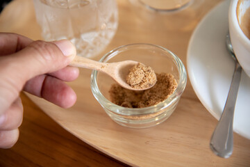 Brown sugar in a wooden spoon.