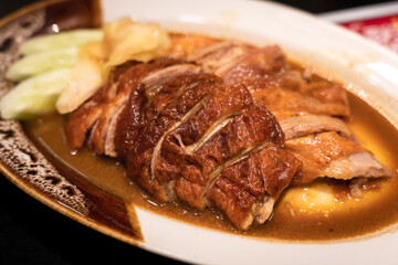 Barbecue roasted duck with soy sauce served in ceramic plate, Chinese traditional food. Selective focus on center.