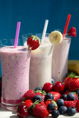 fresh fruit smoothie milkshake with berries blue background