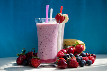 fresh fruit smoothie milkshake with berries blue background