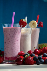 fresh fruit smoothie milkshake with berries blue background