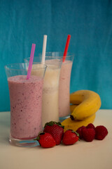 fresh fruit smoothie milkshake with berries and bananas  blue background