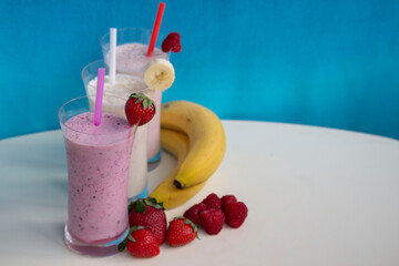 fresh fruit smoothie milkshake with berries and bananas  blue background