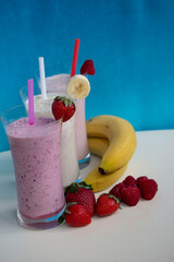 fresh fruit smoothie milkshake with berries and bananas  blue background