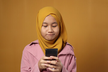 Happy Muslim Teenage Girl Smiling When Chat Messaging on Phone