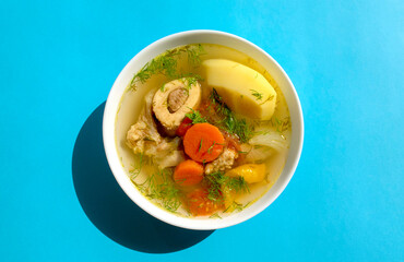Shurpa soup in a white bowl on dark wooden background. Top view. Famous traditional Asian, Uzbek, Middle East soup with beef or lamb and vegetables. Shorpa, sherpa, chorba