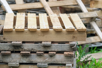 Konzept Recycling oder Entsorgung: Mehrere Paletten unterschiedlicher Größe aus Holz draußen übereinander gestapelt - selektiver Fokus, Textfreiraum