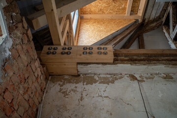 on old building site, old ceiling beams are reinforced with new wooden beams