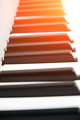 Black and white keys from the piano and synthesizer with bright sunlight.