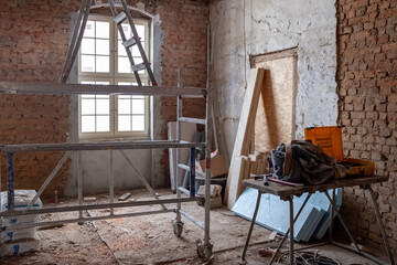 on an old building site there is a scaffold and a ladder in one room